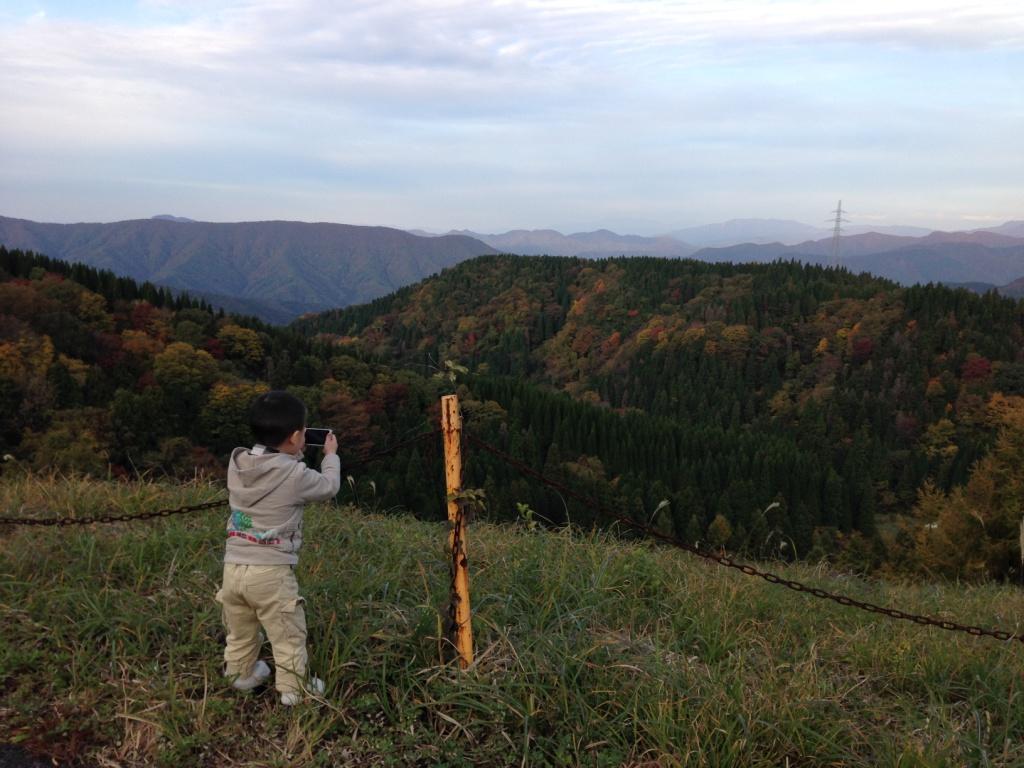 色づいた山を撮る小さなカメラマン